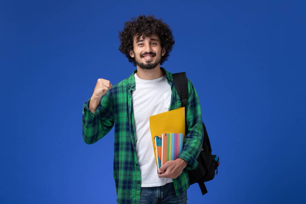 images/blogs/contentImages/front-view-male-student-wearing-black-backpack-holding-copybooks-files-blue-wall (1).jpg